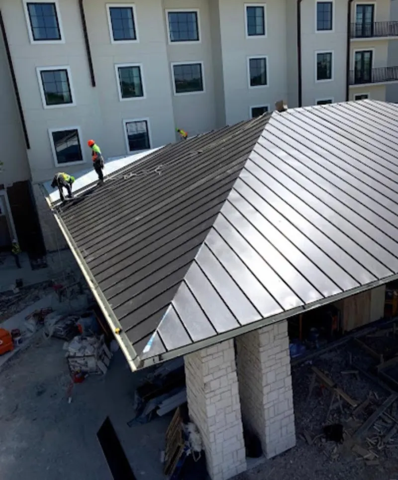 Crew installing standing seam metal roof panels on a commercial project in Ewa Gentry